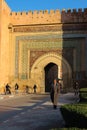 A man in national costume is walking from the beautiful gate of Bab El Khamis