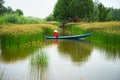 Mekong delta landscape with Vietnamese woman rowing boat on Nang - type of rush tree field, South Vietnam Royalty Free Stock Photo