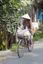 MEKONG DELTA, VIETNAM - MAY 2014: Cycling with vietnamese hat