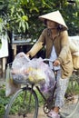 MEKONG DELTA, VIETNAM - MAY 2014: Cycling with vietnamese hat