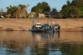 Mekong River Laos from the water showing riverbank activity and ferry boats with cars Royalty Free Stock Photo