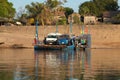 Mekong River Laos from the water showing riverbank activity and ferry boats with cars Royalty Free Stock Photo