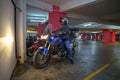 Super Tenere S10 motorcycle with the rider at the basement parking with lights on Royalty Free Stock Photo