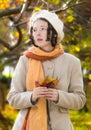 Melancholic girl in a light coat and beret in the park