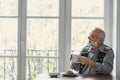 Melancholic grandfather eating breakfast all alone at the table Royalty Free Stock Photo