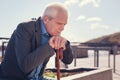 Sorrowful elderly man sitting on the bridge