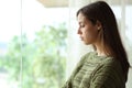 Melancholic woman looking down through a window Royalty Free Stock Photo