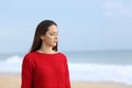 Melancholic woman walking on the beach