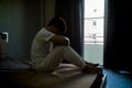 Melancholy man barefoot sitting at the bed embracing his knees, his head down, Feeling problem bored Royalty Free Stock Photo