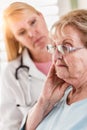 Worried Senior Adult Woman Being Consoled by Female Doctor or Nurse