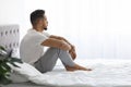 Melancholy. Young Pensive Middle Eastern Man Sitting In Bed And Looking Away Royalty Free Stock Photo