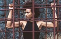 Athlete girl with strong arms after workout behind iron bars Royalty Free Stock Photo