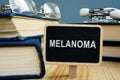 Melanoma disease concept. Books and glasses on desk Royalty Free Stock Photo