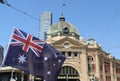 Australian flag in front of Iconic Flinders Street Railway Station in Melbourne