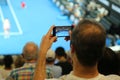 Unidentified spectator uses his cell phone to take images during tennis match at 2019 Australian Open in Melbourne Park Royalty Free Stock Photo