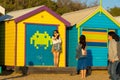 Melbourne, Australia - March 31, 2018: Tourists posing in front of colourful bathing boxes at Brighton Beach, a popular inner city