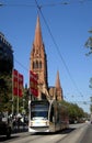 Melbourne public transport- a tram travels along Swanston with St Pauls Cathedral as a background.