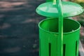 A mellifluous green trash can in the park. New, minimalist trash can. Environmental protection. Space for text