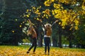 Mellow autumn. Two cheerful girls of student walk in the park. Royalty Free Stock Photo