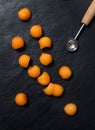 Melon balls with melon baller on stone background