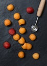 Melon balls with melon baller on stone background