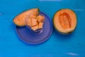 Melon pieces, on white table with blue plate Royalty Free Stock Photo