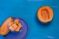 Melon pieces, on white table with blue plate Royalty Free Stock Photo