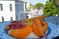 Melon slice with prosciutto crudo in plate at window with Italian urban view