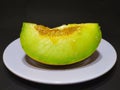 melon slices on a plate with a black background Royalty Free Stock Photo