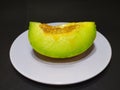 melon slices on a plate with a black background Royalty Free Stock Photo