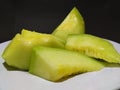 melon slices on a plate with a black background Royalty Free Stock Photo