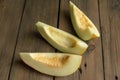 Melon slices on a wooden table. Sweet melon from the garden - three peeled slices. Three slices of honeydew. Royalty Free Stock Photo