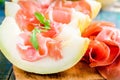 Melon with thin slices of prosciutto and arugula leaves