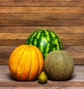 Melons, watermelon and pear on a wooden table