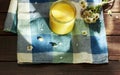 Melted butter ghee in lglass can on textered blue textile