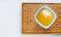 Melted butter on wooden cutting board om white wooden table