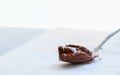 Melted chocolate paste in a spoon on a whte stone background. Cl Royalty Free Stock Photo