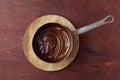 Melted chocolate swirl in pan on the wooden background Royalty Free Stock Photo