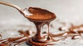 Melted dark chocolate dripping from spoon onto gray surface Royalty Free Stock Photo