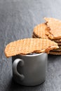 Melted Dutch caramel waffles with cup of coffee on black stone background Royalty Free Stock Photo