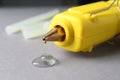 Melted glue dripping out of hot gun nozzle on background, closeup Royalty Free Stock Photo