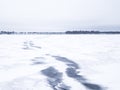 Melted snowmobile tracks on a frozen lake. Royalty Free Stock Photo