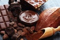 Melting chocolate or melted chocolate with a chocolate swirl and stack, chips and powder on black Royalty Free Stock Photo