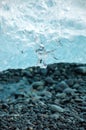 Melting clear ice, dark pebbles, Jokulsarlon, Iceland.