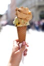 Melting delicious ice cream in waffle cone gelato pistachio salty caramel holding female hand Royalty Free Stock Photo