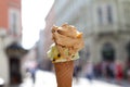 Melting delicious ice cream in waffle cone gelato pistachio salty caramel holding female hand Royalty Free Stock Photo