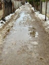 Melting dirty snow on the streets of the city during the daytime in winter. The pedestrian road along the fence has snow Royalty Free Stock Photo