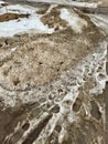 Melting dirty snow on the streets of the city during the daytime in winter. The pedestrian road is snow with sand and Royalty Free Stock Photo