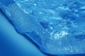 Melting ice cube on light blue background, detail macro Royalty Free Stock Photo