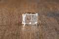 Melting Ice cube with water drops on a table. Royalty Free Stock Photo